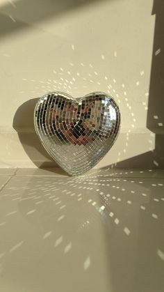 a heart shaped mirror sitting on top of a floor