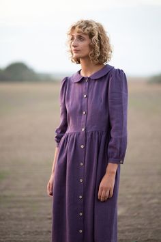 "Midi-length dress made in a soft and washed eggplant color linen. Dress has a slightly fitted bodice with the button placket. Neat, softly rounded collar, long sleeves gathered into cuffs with buttons, hand ruffled skirt - Handmade in our studio from 100% linen - Slightly fitted bodice, gathered skirt with side seam pockets - Long sleeves - Rounded collar - Coconut shell buttons FABRIC&CARE Available in any other linen color, listed in the shop. Linen fabric is medium weight and 100% Oeko-T Parisian Chic Outfits, Cotton Boho Dress, Pan Collar Dress, Outfit Retro, Eggplant Color, Peter Pan Collar Dress, Ruffled Skirt, Top Vintage, Gathered Skirt