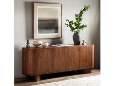 a wooden sideboard with two vases and a painting on the wall above it