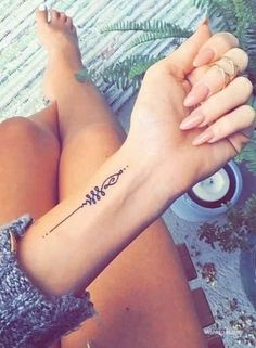 a woman's arm with a tattoo on it, sitting in front of a table