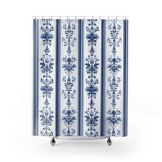 a blue and white shower curtain with floral designs on the outside, in front of a white background