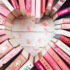 many different colored lipsticks arranged in a circle on top of each other with the word love written across them