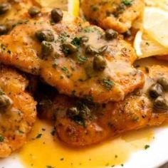 chicken with olives and lemon on a white plate