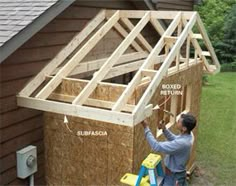 a man is working on the roof of a house that's being built with wooden framing