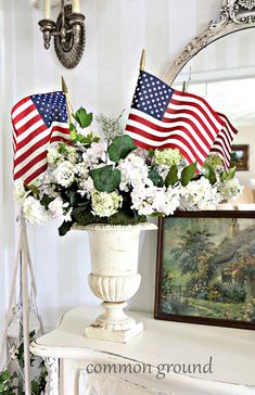 a vase filled with flowers sitting on top of a white table next to a mirror