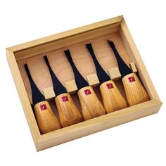 six wooden knives in a box on a white background