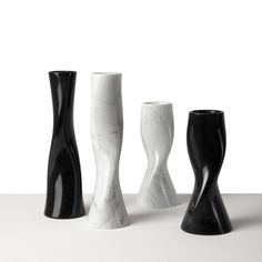 three black and white vases sitting next to each other