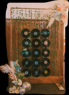 there is a record rack made out of vinyl records and some feathers on the floor