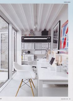 a white desk and chair in front of a window with bookshelves on the wall