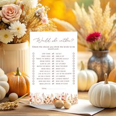 a table topped with lots of flowers and pumpkins next to a white sign that says wild things