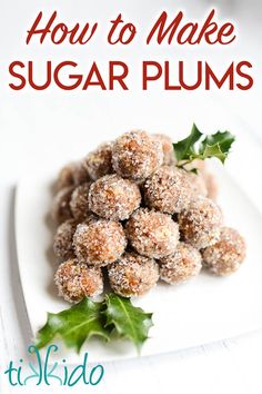 a white plate topped with sugar covered donuts and holly sprinkled on top