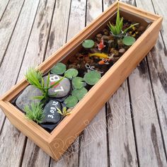 a wooden box filled with rocks and plants