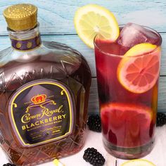 a bottle of crown royal blackberry lemonade next to a glass filled with blackberries