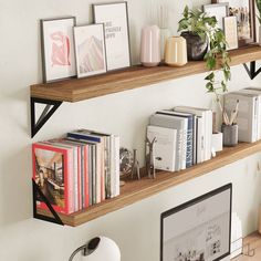 two wooden shelves filled with books on top of a wall next to a computer monitor