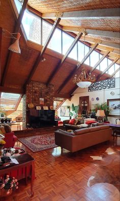 a living room filled with lots of furniture and high vaulted ceilinged windows above it