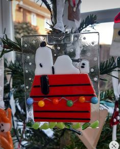 a christmas ornament with two dogs in a sleigh hanging from a tree