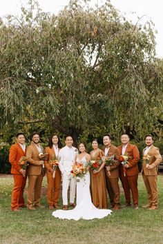 a group of people standing next to each other on top of a grass covered field