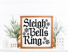 a sign that says sleigh bells ring on it next to some christmas decorations