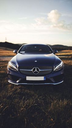 a car is parked in the grass on a sunny day