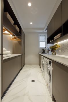 a washer and dryer in a small room with white marble flooring on the walls