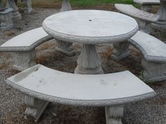 a group of cement benches sitting next to each other on top of a grass covered field