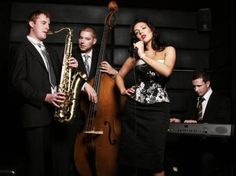 three people are standing in front of a musical instrument