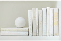 a white ball sitting on top of books next to each other