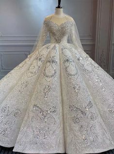 a white ball gown with long sleeves and sequins