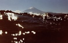 an image of a mountain with lights in the foreground and water on the other side