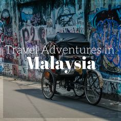 an old bike parked in front of a wall with graffiti on it and the words travel adventures in malaysia