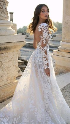 a woman in a white wedding dress standing outside