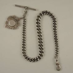 This is an English silver watch chain which has clear hallmarks for Birmingham 1900 The chain weighs in total 52g and measures 310mm from the T bar to the dog clip and is made up of a length of graduated curb links which measures  8mm at their widest point. The chain has an additional link from which hangs a silver fob with hallmarks for Birmingham 1907 The chain and fob are in 95% mint condition. Victorian Silver Curb Chain Jewelry, Victorian Silver Jewelry With Curb Chain, Dog Clip, Pocket Watch Chain, Watch Chain, Silver Watch, The Dog, Birmingham, Mint Condition