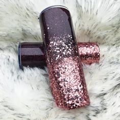 a pink and black glitter tube laying on top of a white fur covered floor with it's end in the air