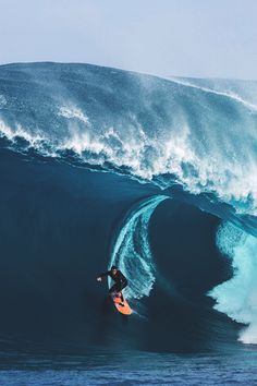 a man riding a wave on top of a surfboard