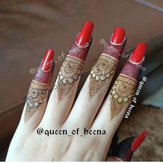 a woman's hand with red and gold henna tattoos on her fingers,