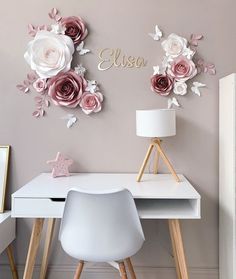 a white desk with flowers on the wall