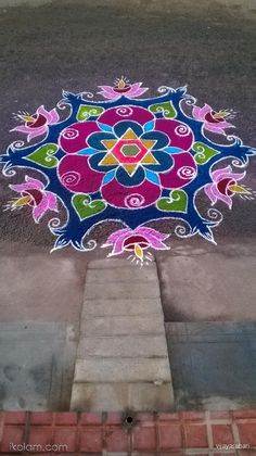 a colorful design on the ground next to a sidewalk