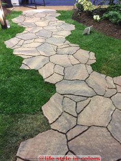 a walkway made out of stone in the grass