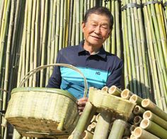 an old man holding a basket full of bamboo sticks