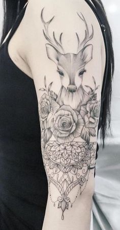 a woman's arm with a deer and roses tattoo on the left side of her arm