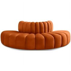 an orange curved couch sitting on top of a white floor