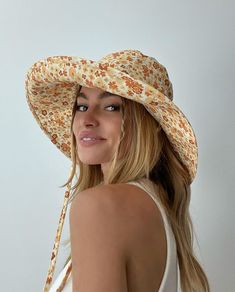 a woman wearing a yellow floral hat