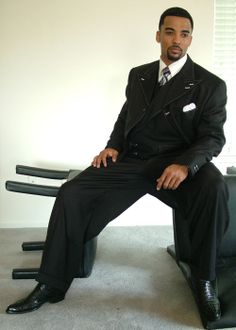 a man in a suit and tie sitting on a chair