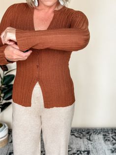 Our Nonchalant knit cardigan offers a cozy v-neck and split hem, perfect for a casual day out. The button down design adds a touch of elegance, while the copper color adds a pop to any outfit. With a fitted silhouette and a blend of 75% acrylic and 25% nylon, this cardigan is both stylish and comfortable. Amanda is wearing a small, Betty a medium. Besties: Reverse It, Flexible, Laid Back, Dress Up, LBD, Longer Days, The Staple, Hey Boots, Informal, Day Trip, Beloved Blazer Elegant V-neck Cardigan With Textured Knit, Chic V-neck Textured Knit Cardigan, Brown Knit Open Front Cardigan, Elegant V-neck Stretch Cardigan, Stretch Open Knit V-neck Cardigan, Flair Dress, Split Hem, Copper Color, Jewelry Bags