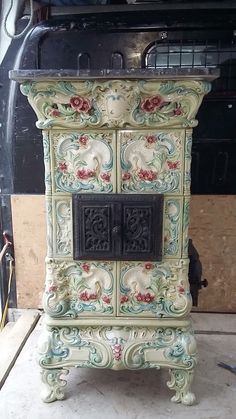 an ornately painted cabinet sitting on top of a floor