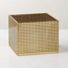 a golden square basket sitting on top of a white table