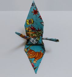 a blue origami kite with an animal design on it's front and sides