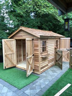 a wooden shed sitting on top of a lush green field