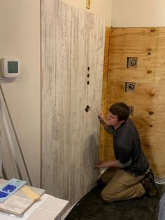 a man working on a wall in a room