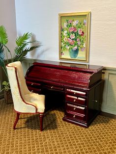 a miniature desk and chair in front of a painting on the wall with a potted plant next to it